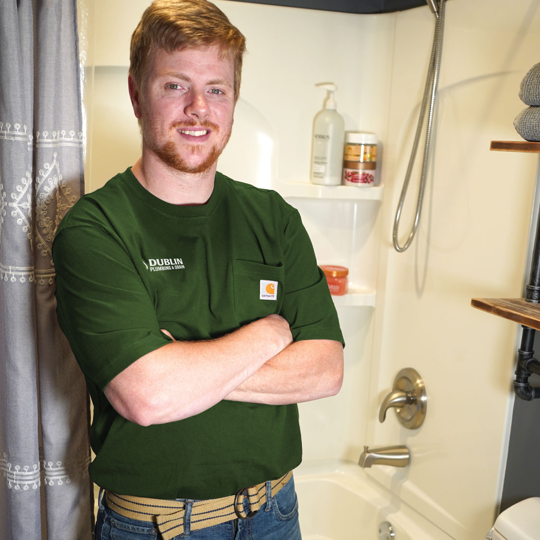 Plumber in front of a bathtub and show